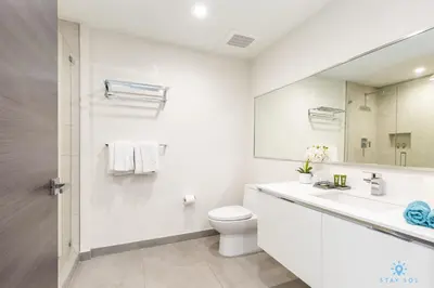 a white bathroom with a toilet and a sink at Costa Hollywood Beach in Hollywood