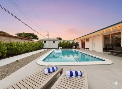 a swimming pool with two chairs and a house at Private Pool Villa Tropical Retreat Near Beach in Fort Lauderdale