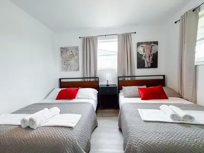 two beds in a bedroom with red pillows on them at Private Pool Villa Tropical Retreat Near Beach in Fort Lauderdale