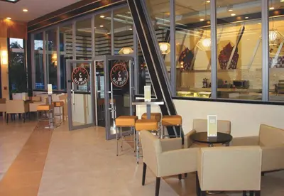 a restaurant with tables and chairs and windows at Riu Plaza Miami Beach in Miami Beach