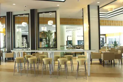 a restaurant with a bar and stools in a lobby at Riu Plaza Miami Beach in Miami Beach