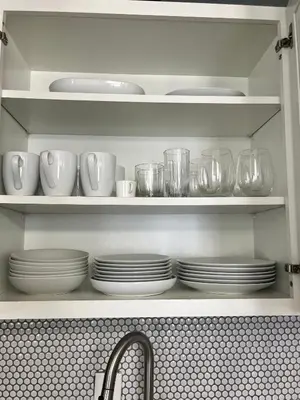 a kitchen shelf with plates and cups and a sink at Ocean Dream by the Beach in Miami Beach
