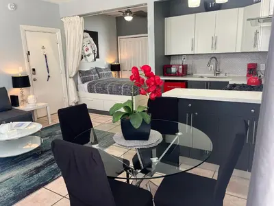 a kitchen with a glass table with a vase with red flowers at Ocean Dream by the Beach in Miami Beach