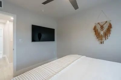a white bedroom with a bed and a tv on the wall at New! Miami & Calle Ocho Simpson's Funhouse! in Miami