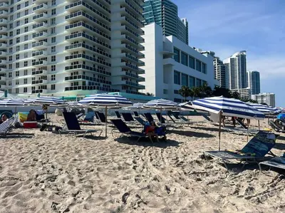 a group of chairs and umbrellas on a beach at Modern 1B 1B with Kitchen & Stunning Miami Beach Views in Hallandale Beach