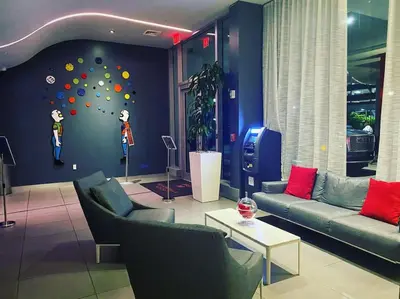 a living room with couches and a wall with a ball wall at Modern Apt by the Beach with Full Kitchen -A in Hallandale Beach