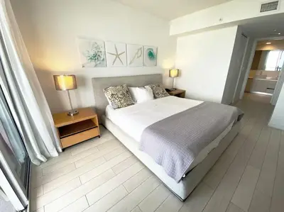 a bedroom with a large bed and two lamps on tables at Luxury Miami Beach Retreat, Ocean at Your Doorstep -A in Hallandale Beach