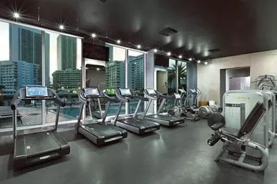 a gym with treadmills and ellipticals in a building at Luxury Miami Beach Retreat, Ocean at Your Doorstep -A in Hallandale Beach