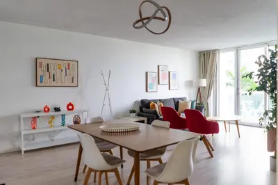 a living room with a dining room table and red chairs at Apartment on the beach Tides Hollywood Beach 5th floor U in Hollywood