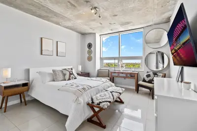 a white bedroom with a bed and a desk at Quiet & central Apt in Midtown Miami in Miami