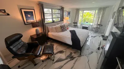 a bedroom with a bed and a chair at Paradise Gardens-Wilton Manors- Male only in Fort Lauderdale