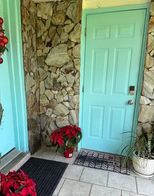 a blue door of a house with a stone wall at Paradise Gardens-Wilton Manors- Male only in Fort Lauderdale