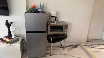 a kitchen with a microwave and a table with a chair at Paradise Gardens-Wilton Manors- Male only in Fort Lauderdale