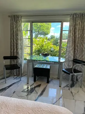a room with a glass table and two chairs and a window at Paradise Gardens-Wilton Manors- Male only in Fort Lauderdale