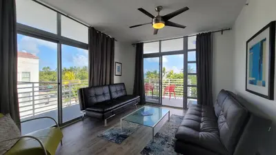 a living room with a couch and a ceiling fan at Strand Ocean Drive Suites in Miami Beach