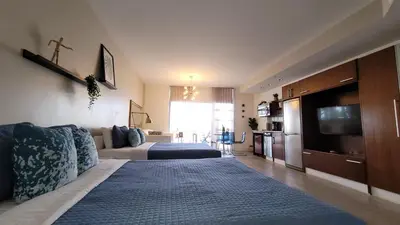 a large living room with a bed and a kitchen at Strand Ocean Drive Suites in Miami Beach