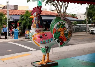 a statue of a chicken sitting on a sidewalk at Heart of Little Havana Awaits in Miami