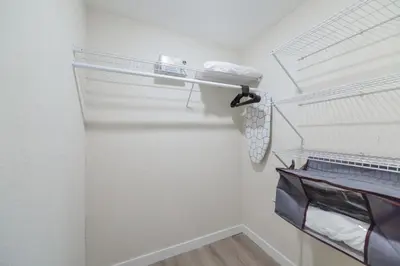 a walk in closet with white walls and white shelves at Amazing Experience in Calle Ocho in Miami