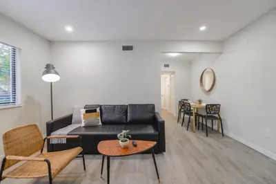 a living room with a black couch and a table at Apartment in Calle Ocho a Slice of Little Havana in Miami