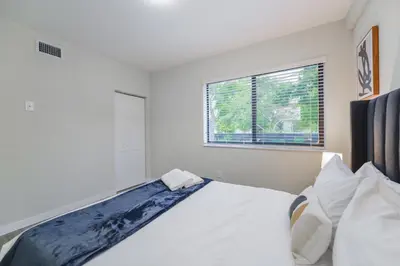 a white bedroom with a bed and a window at Apartment in Calle Ocho a Slice of Little Havana in Miami