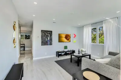 a living room with a couch and a table at Hallandale Collection - Renovated Professional Design & Lake View in Ro-Len Lake Gardens