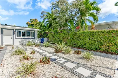 a home with a garden and a house at Hallandale Collection - Renovated Professional Design & Lake View in Ro-Len Lake Gardens