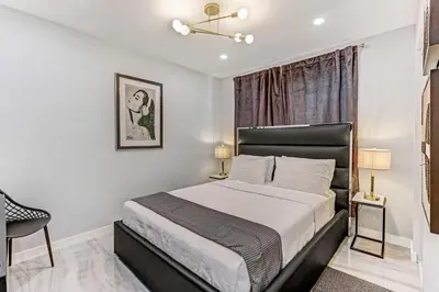 a bedroom with a bed and a chair and a window at Hallandale Collection - Renovated Professional Design & Lake View in Ro-Len Lake Gardens