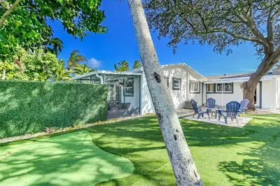 a house with a lawn and a tree at Hallandale Collection - Renovated Professional Design & Lake View in Ro-Len Lake Gardens