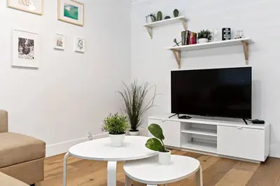 a white living room with a flat screen tv at Charming Apartment near Las Olas Blvd in Fort Lauderdale