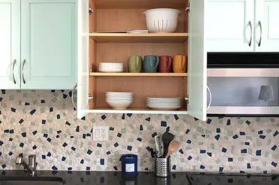 a kitchen with white cabinets with plates and bowls at Las Olas Blvd Waterfront Apt in Fort Lauderdale