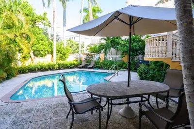 a table with an umbrella next to a swimming pool at Beach Apt with Waterview in Las Olas Blvd in Fort Lauderdale