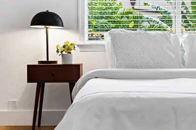 a bedroom with a bed and a table with a lamp at Spacious Beach Apt in Las Olas Blvd in Fort Lauderdale