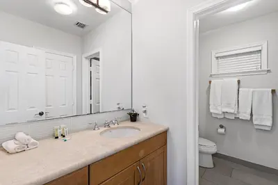 a bathroom with a sink and a toilet and a mirror at Relaxing Beach Apt in las Olas Blvd in Fort Lauderdale