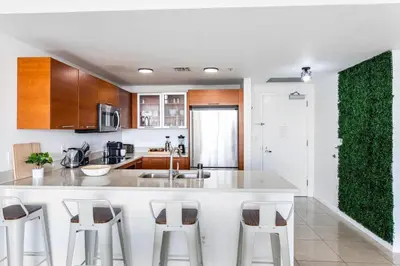 a kitchen with a white counter and bar stools at Coco Loco - Wynwood in Miami