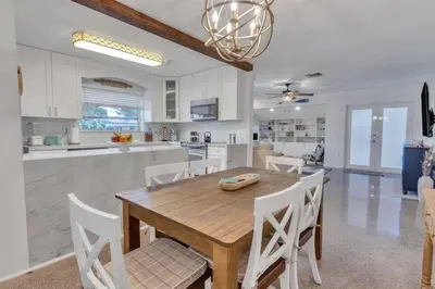 a kitchen and dining room with a wooden table and chairs at 7-Person Luxury Spa, Fenced Paradise, Beach Vibes in Pembroke Pines