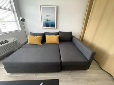 a couch in a living room with yellow pillows at North Shore Oasis - Steps to Miami Beach Bliss in Miami Beach