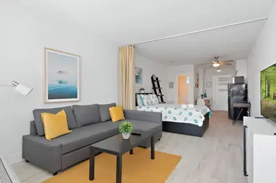 a living room with a couch and a bed at North Shore Oasis - Steps to Miami Beach Bliss in Miami Beach