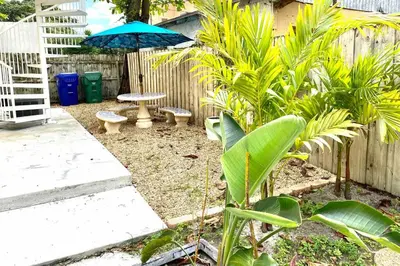 a garden with a table and a blue umbrella at ZION Miami Design District 2 Bedroom amongst the trees! in Miami