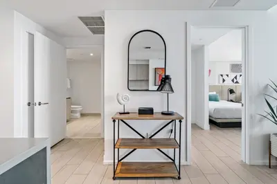 a room with a table with a mirror and a bed at Oceanview 2BR and luxury amenities at Hyde Beach House in Hollywood