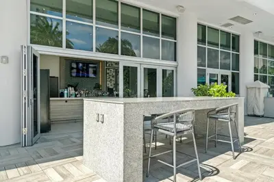 an outdoor kitchen with a bar and chairs at Oceanview 2BR and luxury amenities at Hyde Beach House in Hollywood