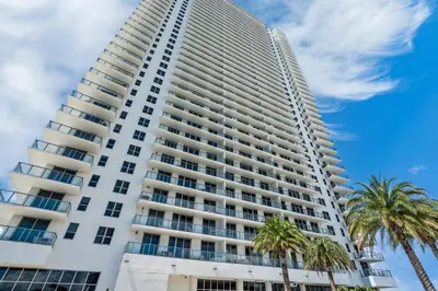 a tall white building with palm trees in front of it at Oceanview 2BR and luxury amenities at Hyde Beach House in Hollywood