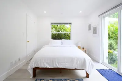 a white bedroom with a bed and a window at Bright & Comfortable Apt in Victoria Park in Fort Lauderdale