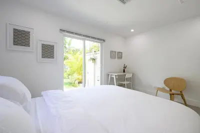 a white bedroom with a large bed and a window at Bright & Comfortable Apt in Victoria Park in Fort Lauderdale