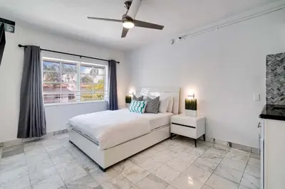 a white bedroom with a bed and a window at Best location by the Beach ! Free WiFi - TV - All amenities 103 in Miami Beach