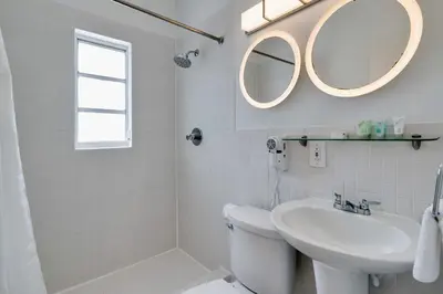 a white bathroom with a sink and a mirror at Best location by the Beach ! Free WiFi - TV - All amenities 103 in Miami Beach