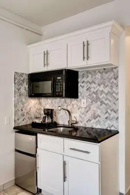 a kitchen with white cabinets and a sink and a microwave at Best location by the Beach ! Free WiFi - TV - All amenities 103 in Miami Beach