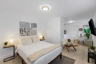 a white bedroom with a bed and a dining room at Lake Ridge Villa in Fort Lauderdale
