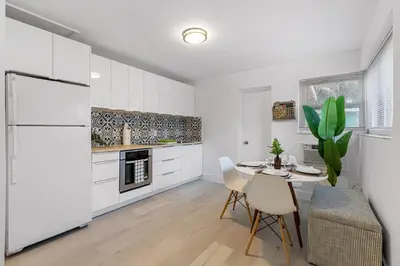 a kitchen with white cabinets and a table and chairs at Lake Ridge Villa in Fort Lauderdale