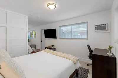 a bedroom with a bed and a desk and a television at Lake Ridge Villa in Fort Lauderdale