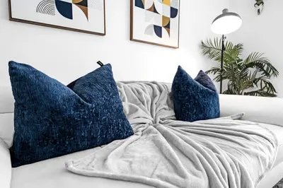 a white couch with blue pillows on it at Amazing 2 Bedroom Unit In Doral Miami With Free Parking in Hialeah Gardens